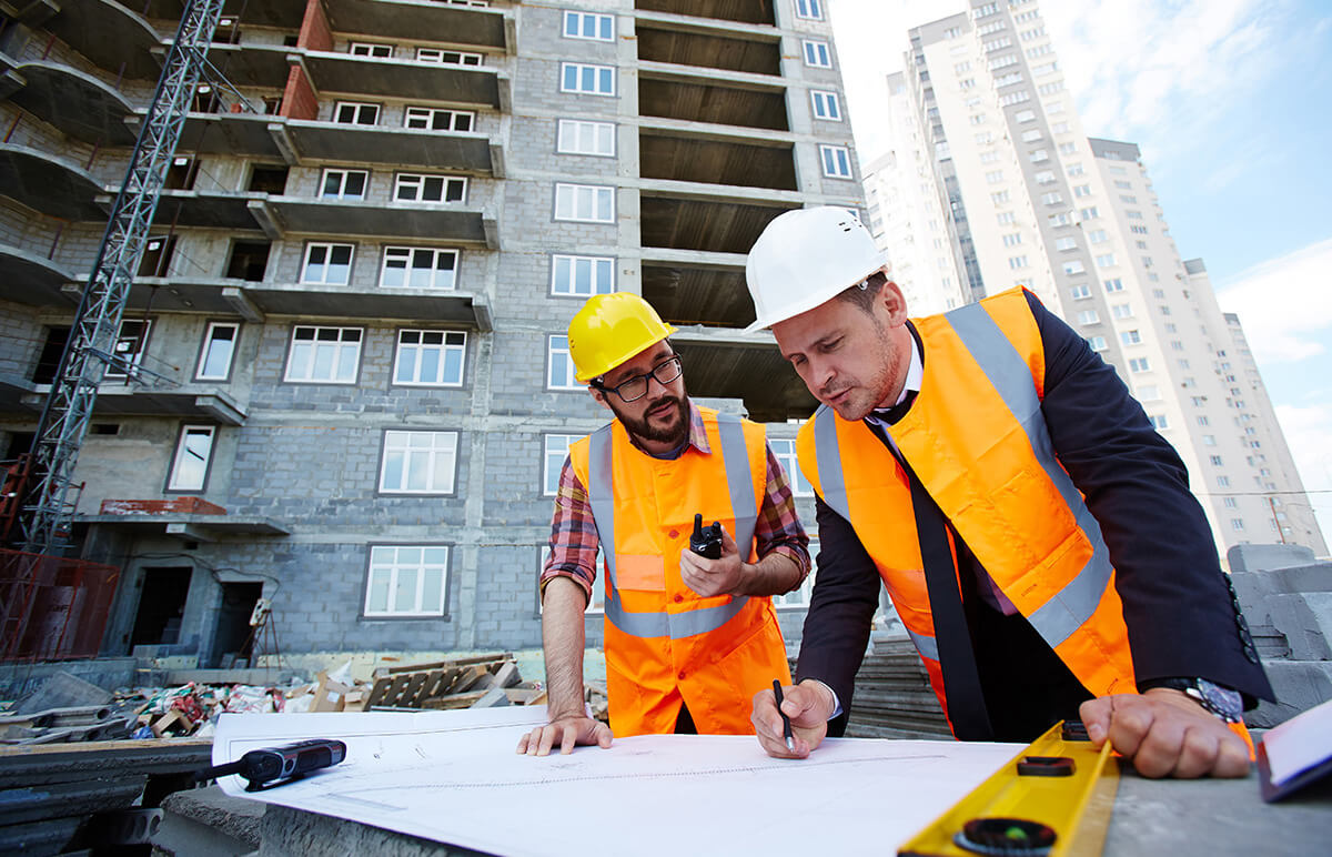 Two workers examining blueprints