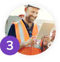 Smiling construction worker looking at a laptop