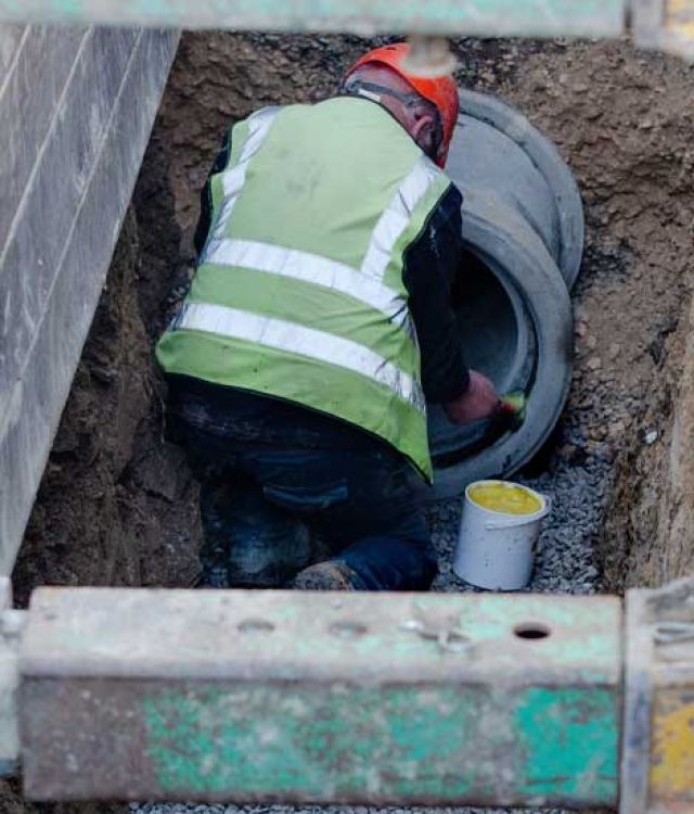 Man working on a drainage pipe