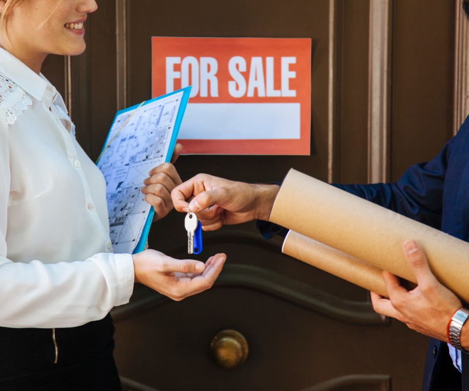 Woman receiving key from real estate agent